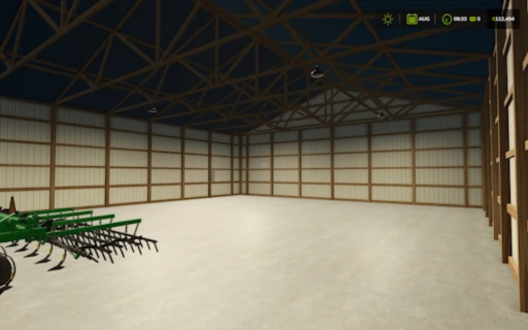 Interior view of 54x72 Shed mod in FS25, showcasing spacious area with wooden beams and partial machinery. Farming Simulator 25 mods.