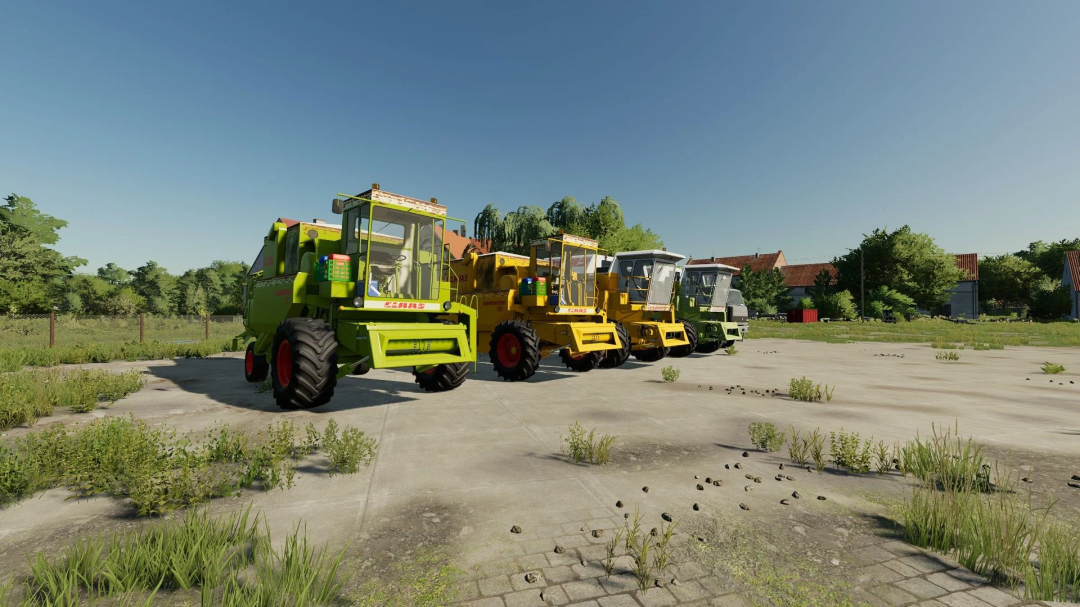 Four CLAAS combine harvesters from the FS22 mods pack on a field, under clear skies.