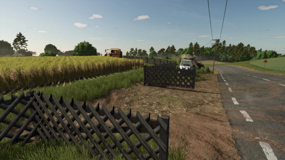 Hunter Fence mod in Farming Simulator 25 showcasing dark fence along fields and rustic road.