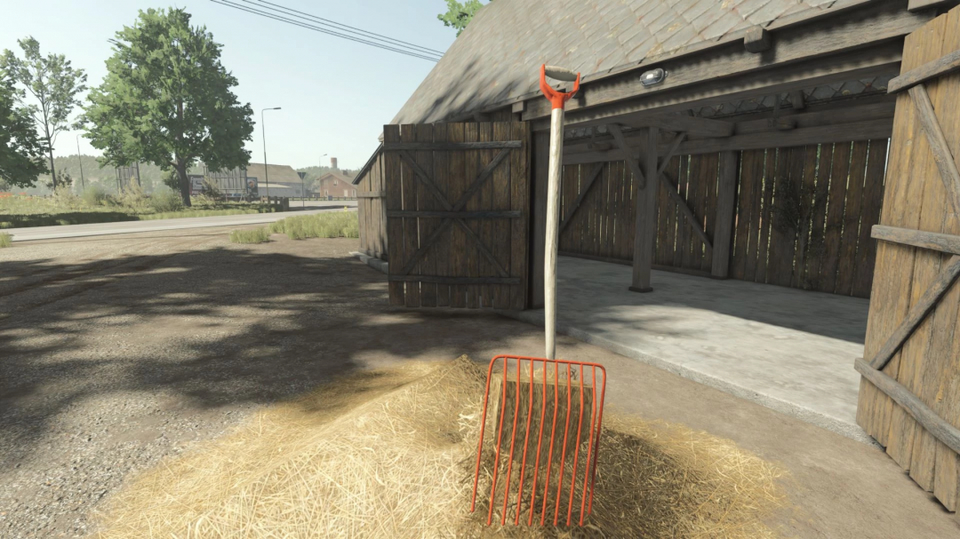 Straw fork mod for FS25 beside hay in a barnyard setting.