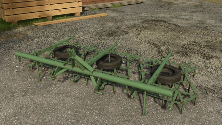 fs25-mods, Harrows mod in Farming Simulator 25, showcasing a green agricultural tool on gravel ground. FS25 mods enhance gameplay.