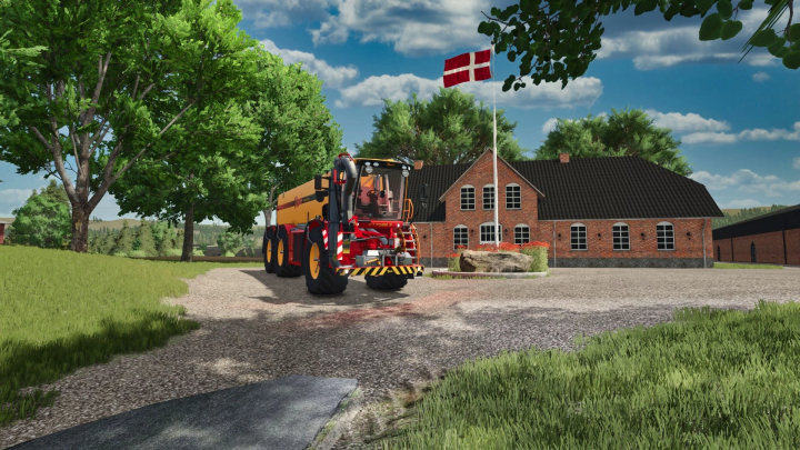 fs25-mods,  Vredo VT70283 mod in FS25 near a brick farmhouse and Danish flag.