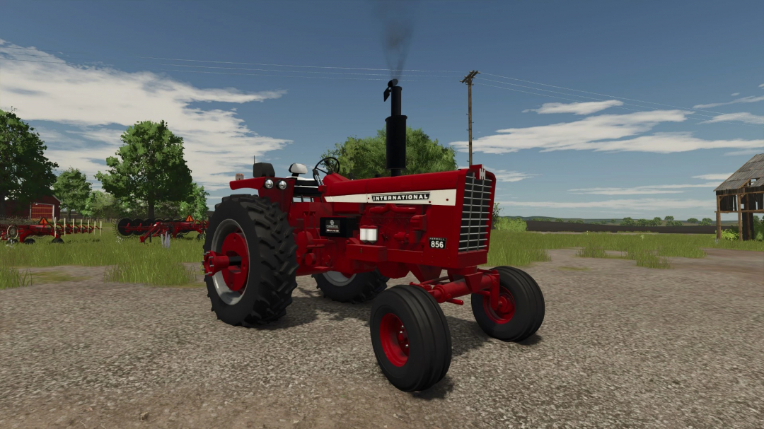 International 856 tractor mod in FS25, parked on a gravel road with green fields and an old barn.