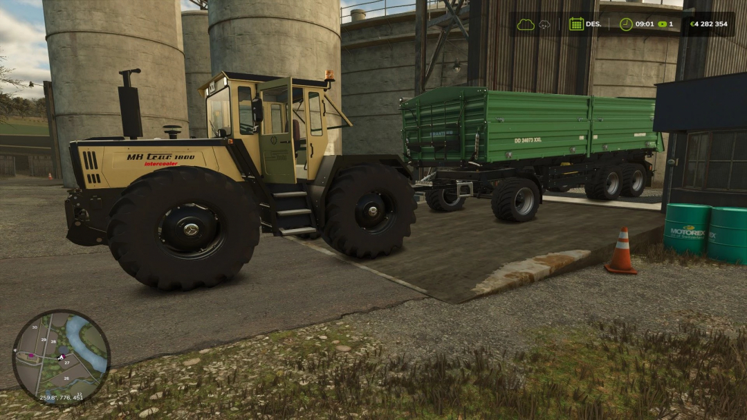 Farming Simulator 25 mod: MB Trac Stotz v1.0.0.1 showing a large tractor towing a green trailer in an industrial setting.