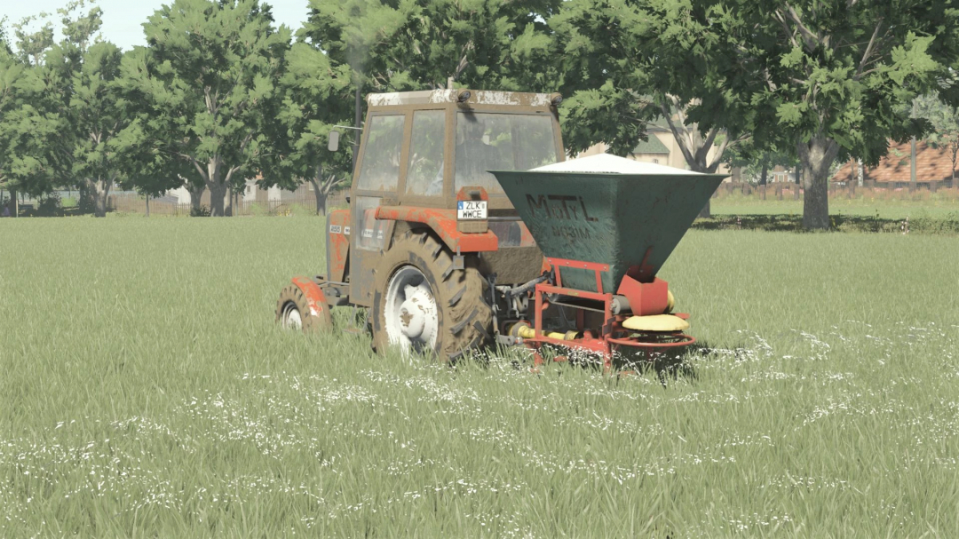 Tractor with POM Motyl NO13 spreader on a grassy field in FS25 mod.