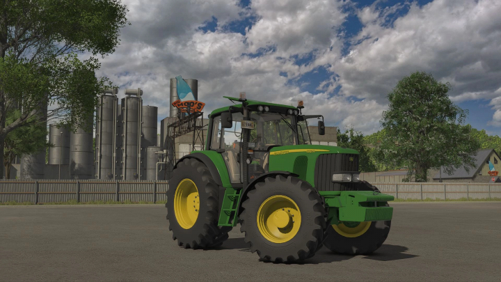 fs25-mods, John Deere 6x20 Series tractor mod in Farming Simulator 25, parked in an industrial area with silos and trees in the background.