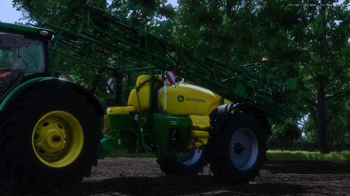 fs25-mods, John Deere R700i sprayer mod in FS25 game, showcasing green and yellow equipment attached to a tractor amidst trees.