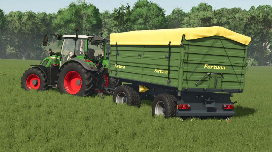 FS25 mod Fortuna K180 v1.0.0.0 with green and yellow trailer attached to a tractor in a grassy field.