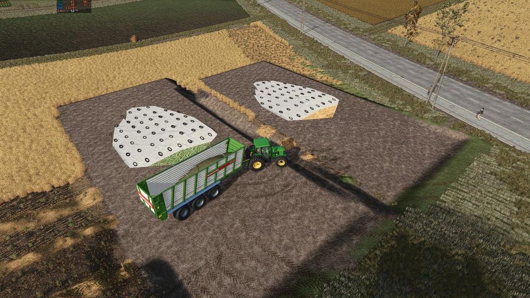 FS25 mods: Hay and straw silos mod with a tractor and trailer in Farming Simulator 25.