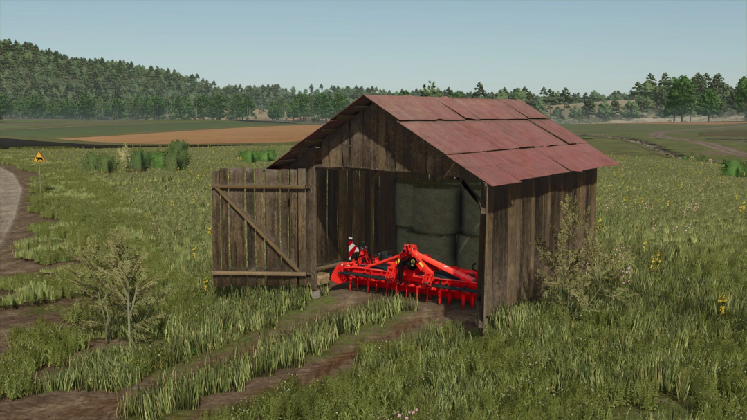 Old Shed mod in FS25, featuring a rustic wooden shed storing farming equipment and hay bales in a rural landscape.