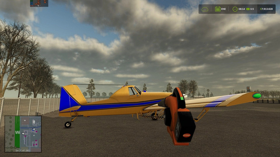 Stihl blower in Farming Simulator 25 mod, showing a yellow and blue aircraft on a cloudy day. FS25 mods enhance gameplay visuals.