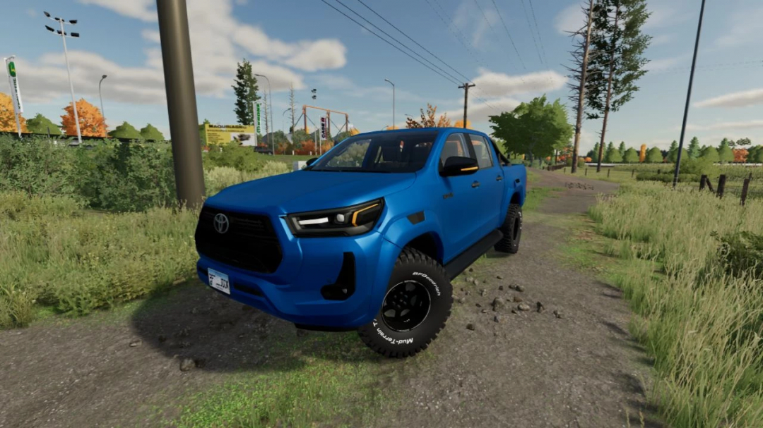 Toyota Hilux 2022 mod in FS22, blue pickup truck on a rural road.