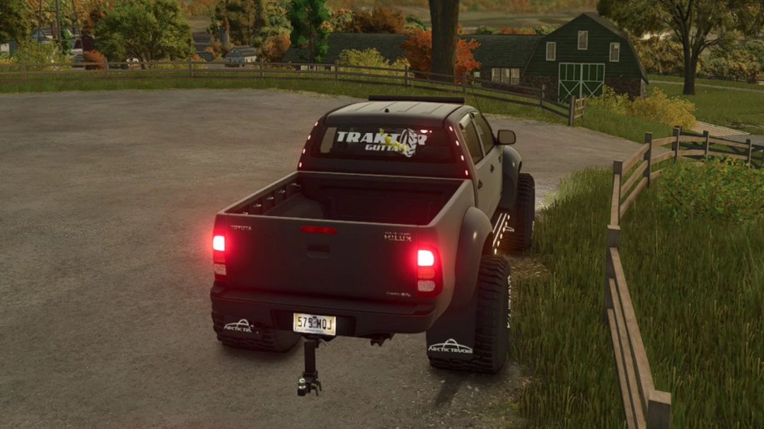 Toyota Hilux AT38 Edit mod in FS25, showcasing a rugged truck on a farm road with lush green scenery.