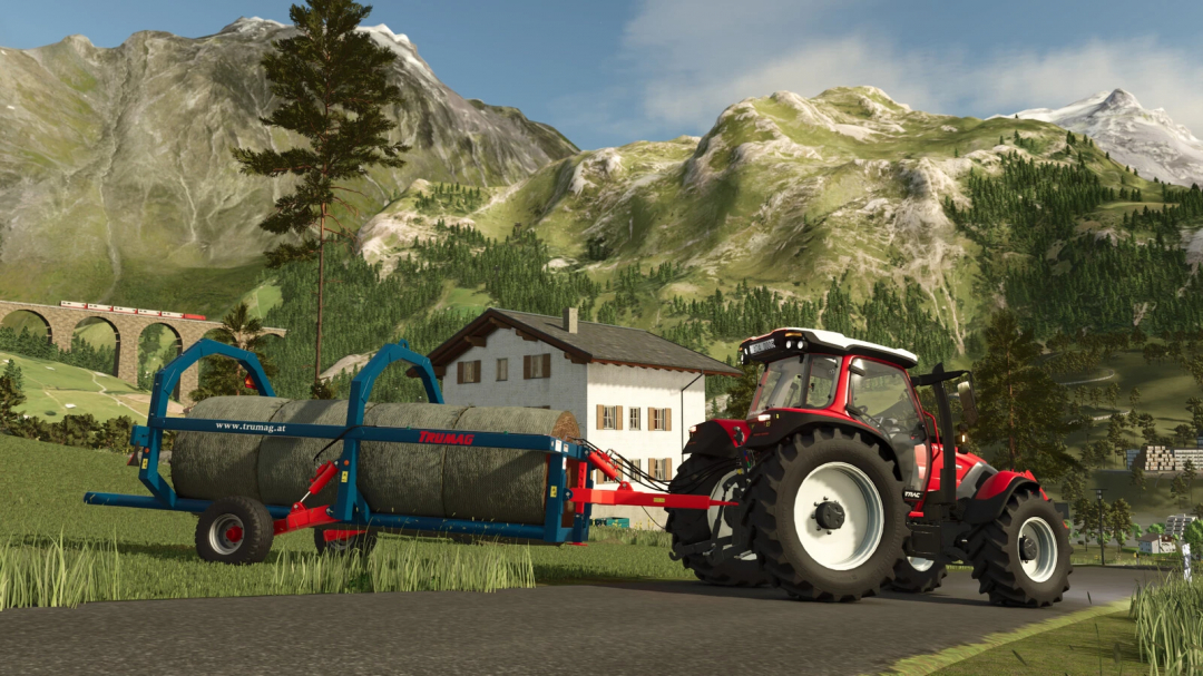 FS25 mod Trumag RBTW v1.0.0.0 showing a tractor towing a bale transporter in a picturesque mountain setting.