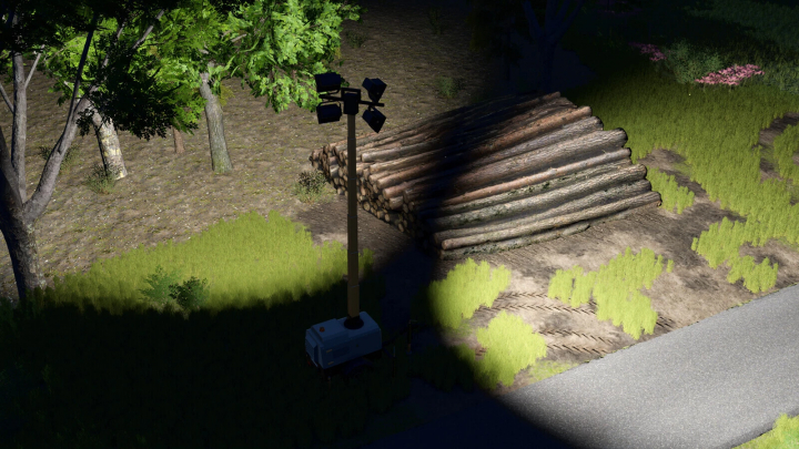 fs25-mods,  Flood Light Trailer mod in FS25, illuminating a log pile beside trees at night.