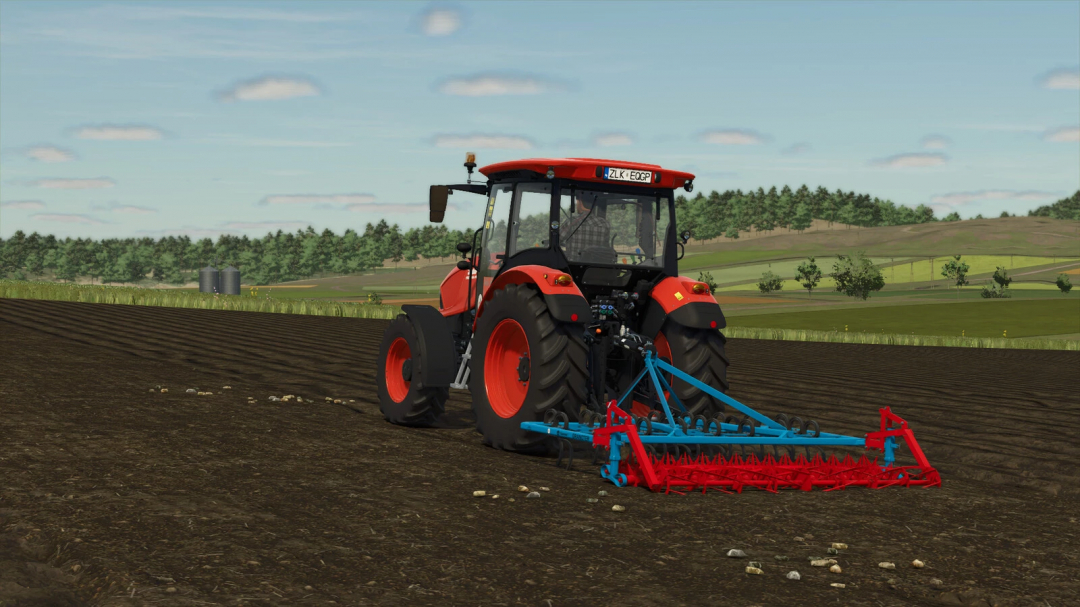 Tractor using Gorenc Granoter 280 mod in FS25, cultivating a field with trees and silos in the background.