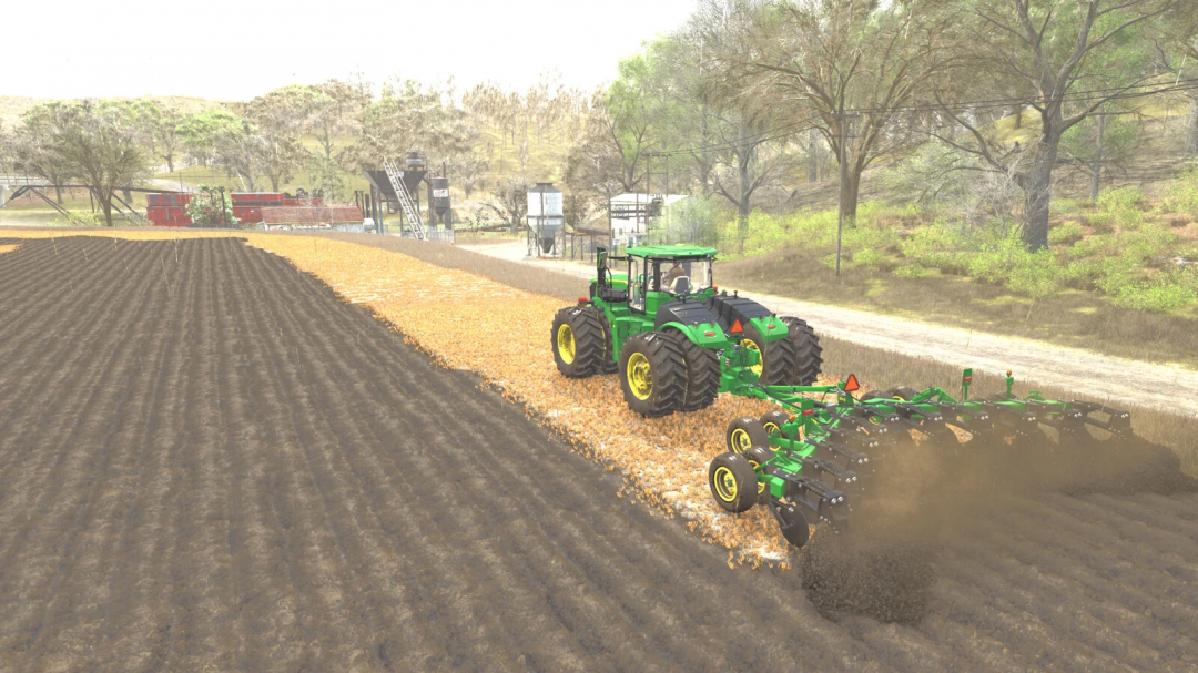 John Deere 915V-Ripper mod in FS25 cultivating a field with trees and farm buildings in background.