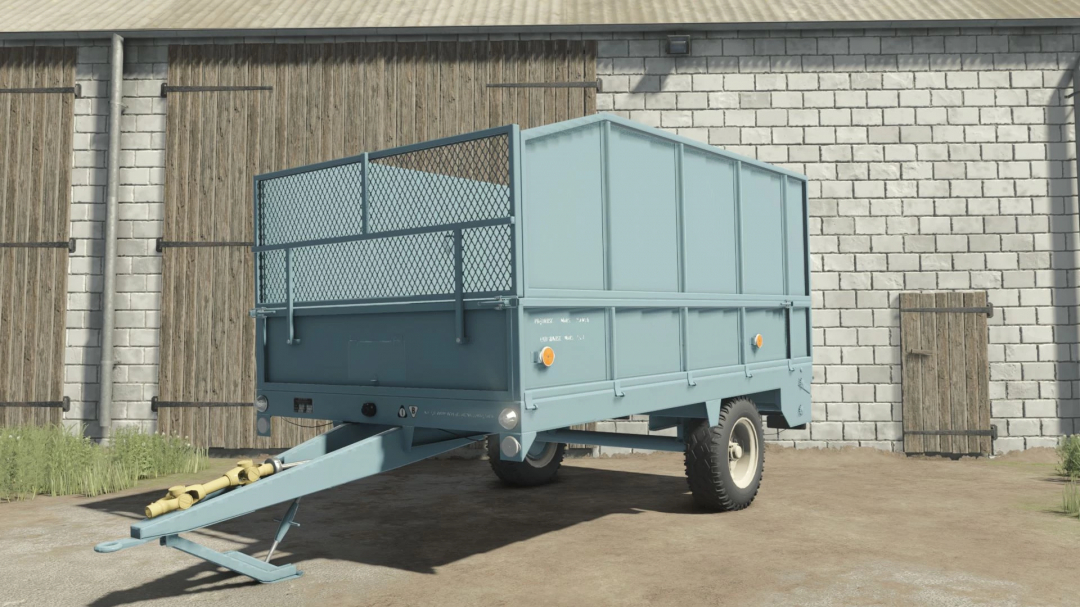 FS25 mod Agromet Warfama N-237/1 trailer in front of a barn in Farming Simulator 25.