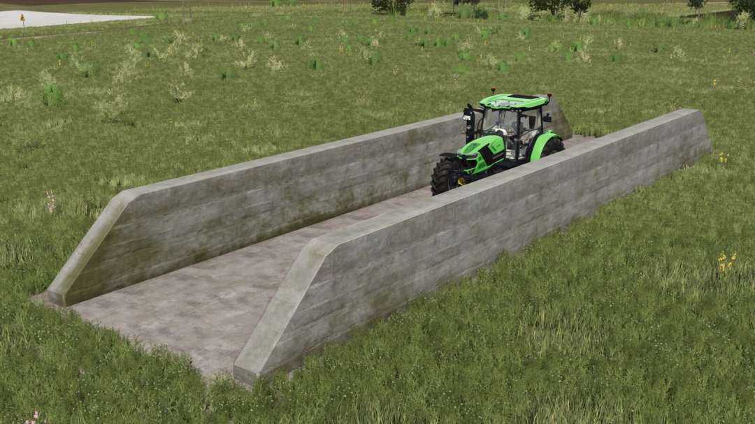 FS25 mod Big White Cow Barn v1.0.0.0 with a green tractor inside a concrete pit in a grassy field.