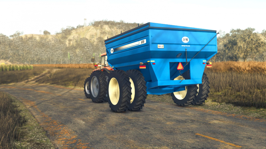 FS25 875 Grain Cart mod in Farming Simulator 25, showing a blue grain cart hitched to a tractor on a rural road.