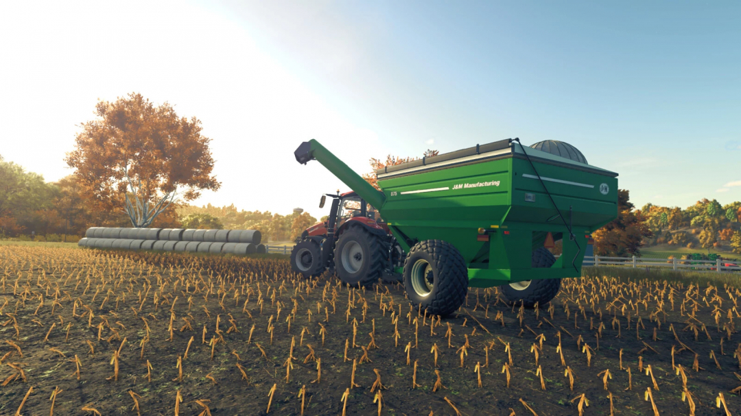 FS25 mod showing a tractor towing an 875 Grain Cart v1.0.0.0 in a harvested field with hay bales and autumn trees.