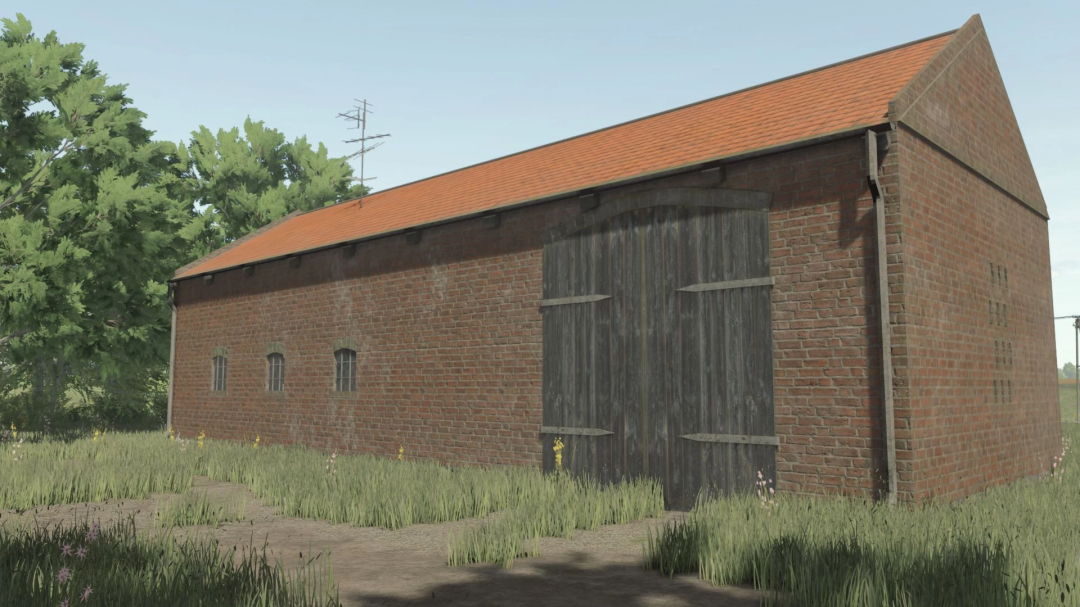 Brick German barn mod in FS25 with wooden doors and a red-tiled roof, surrounded by grass and trees.