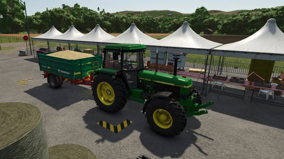 Tractor with trailer at agricultural fair in FS25 mod. Tents and products displayed in the background.