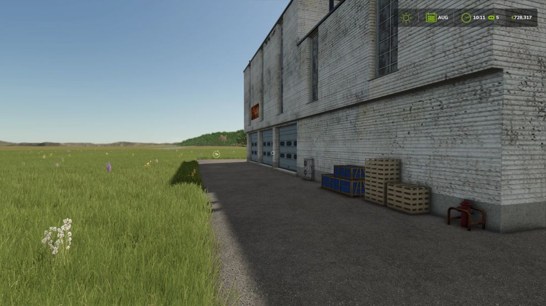 Exterior of a beer production facility in FS25 mod, showing a grassy field, crates, and loading docks.