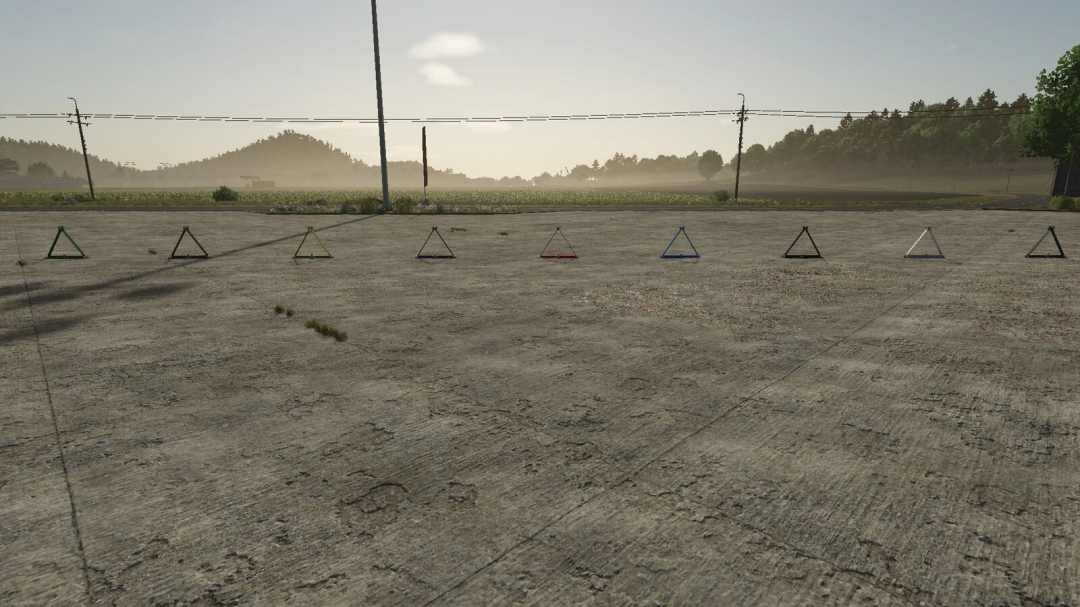 Various colored triangular frames on a concrete floor in Farming Simulator 25, showing Farm Rail Triangle mod.