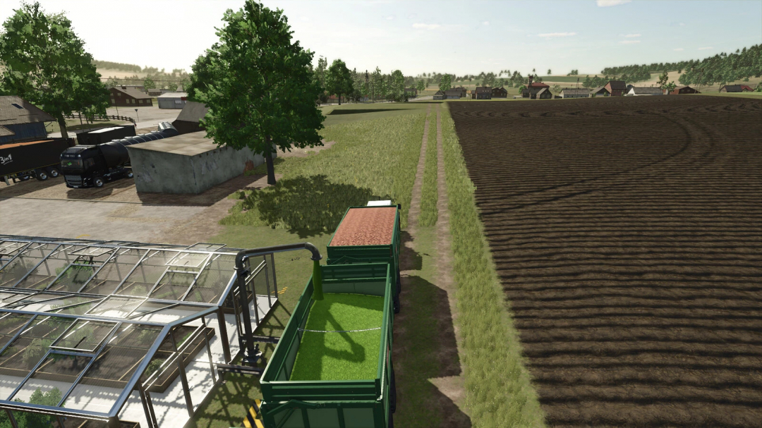 A view of a farm in FS25 with a fruit greenhouse, fields, and trucks, showcasing the Fruit Greenhouse mod v1.1.0.0.