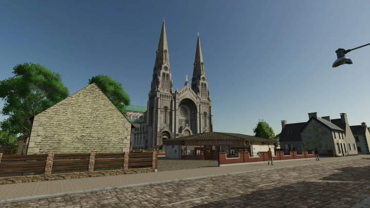 fs25-mods, View of La Ferme de la Vallée Extension mod in FS25 with a cathedral, trees, and buildings.