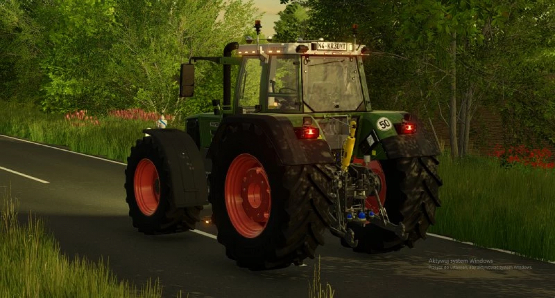 FS22 Fendt 800/900 Favorit EDIT mod showcasing a rear view of a tractor on a road, surrounded by greenery. Ideal for Farming Simulator 22 mods.