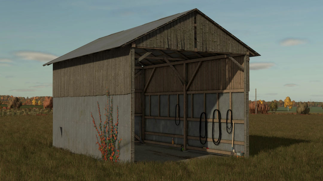 Harvester Shed v1.0.0.0 mod for FS25, showcasing a rustic barn in a grassy field, perfect for storing farming equipment.