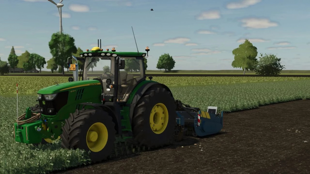 Green tractor using Imants Pack v1.0.0.0 mod in FS25, cultivating a field under a bright sky.