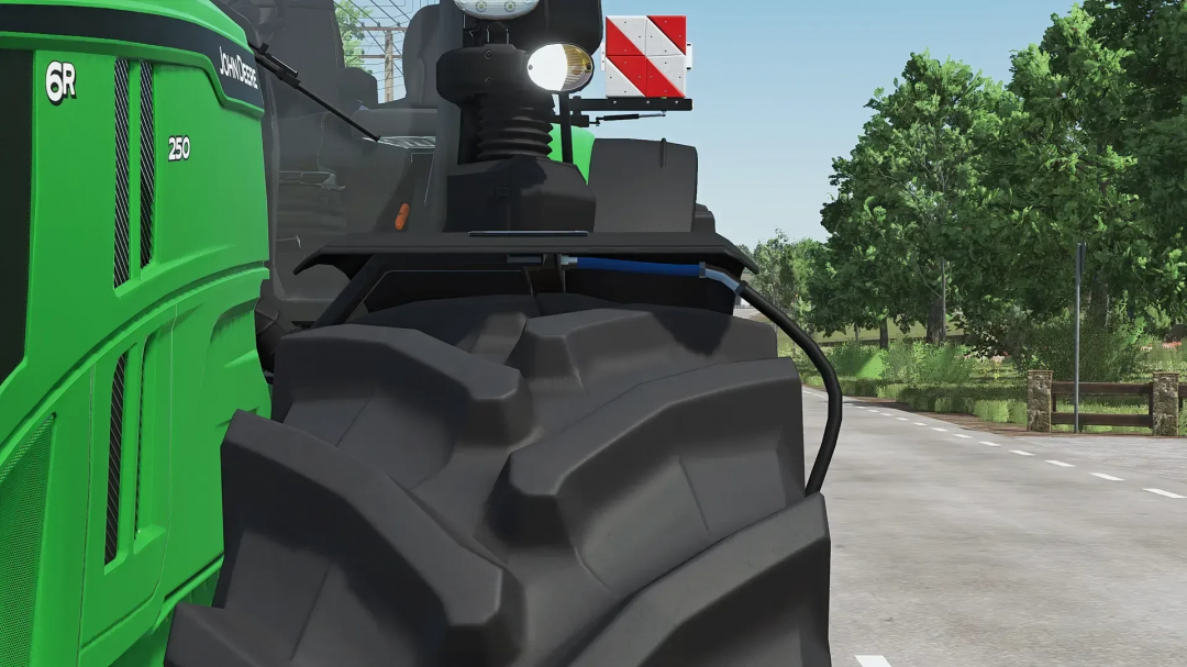 Close-up of the John Deere 6R tractor mod in FS25, showing detailed tire and bodywork in Farming Simulator 25.