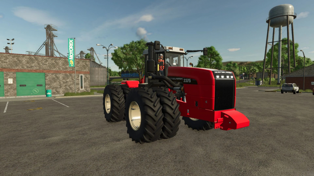 Rostselmash RSM 2375 mod in FS25, red tractor parked near buildings and a water tower.