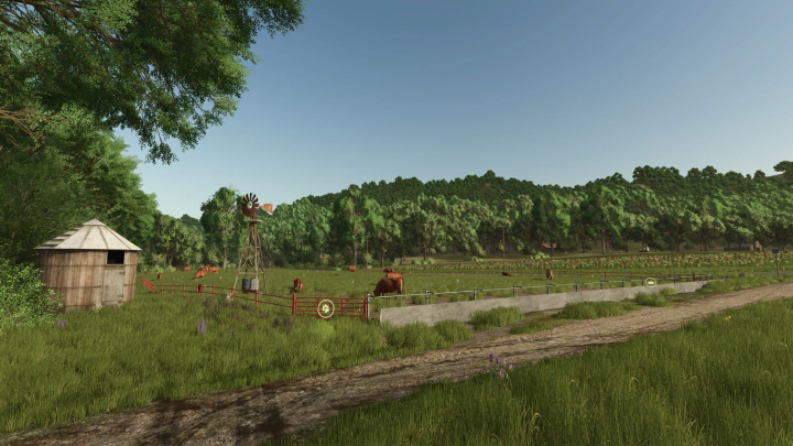 fs25-mods, Buildable Feedlot Pack mod for FS25 showing cows grazing in a fenced area with trees and a barn in the background.