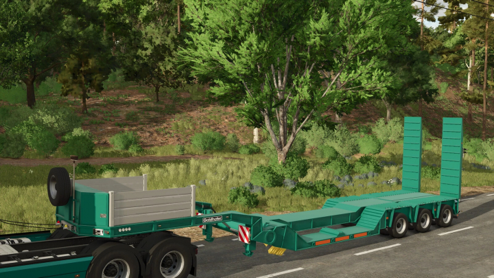 fs25-mods, Goldhofer STZ Special Lowloader mod in Farming Simulator 25, displayed on a rural road with lush trees in the background.