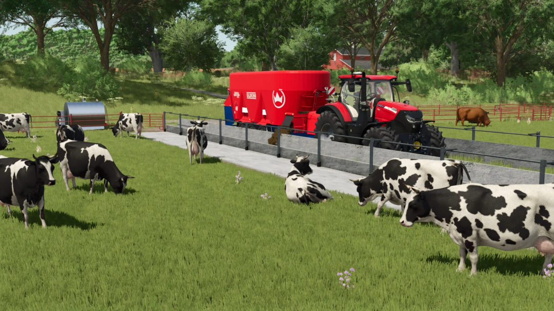 Cows grazing near a red tractor and feed mixer in FS25 mod, Buildable Feedlot Pack.