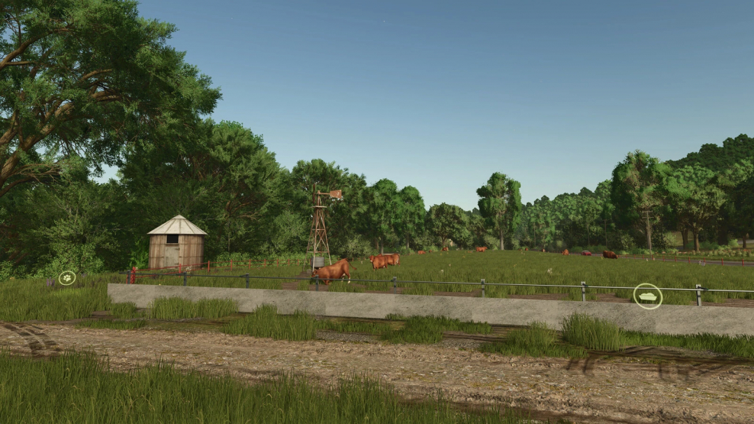 FS25 mod Buildable Feedlot Pack v1.0.0.0 showcasing cows grazing in a lush pasture with trees and a windmill, adding realism to Farming Simulator 25.