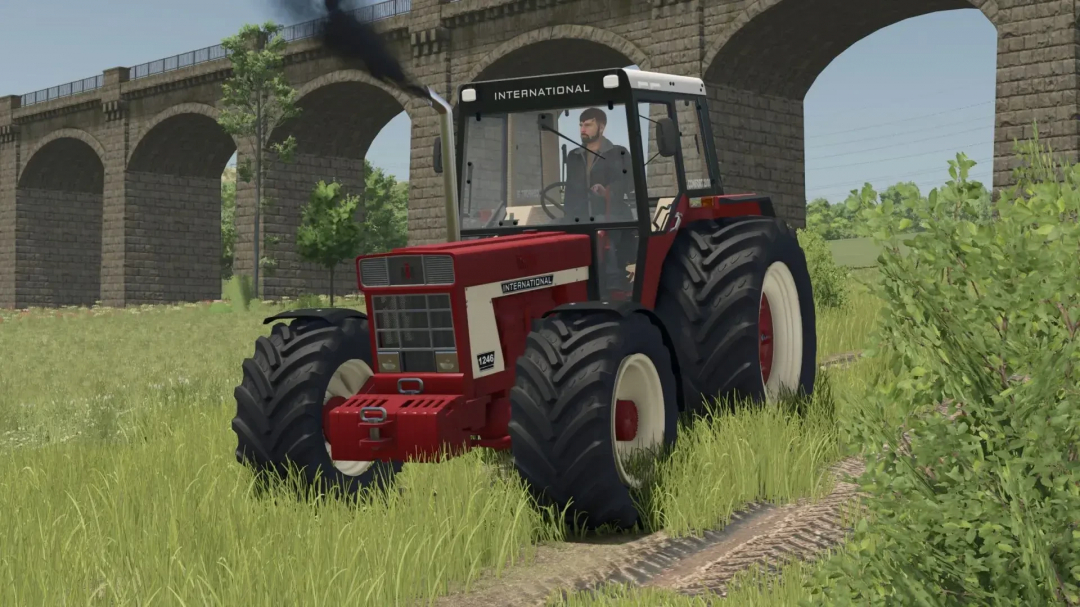 IHC 1046 tractor mod in FS25, driving through grass by an old viaduct.