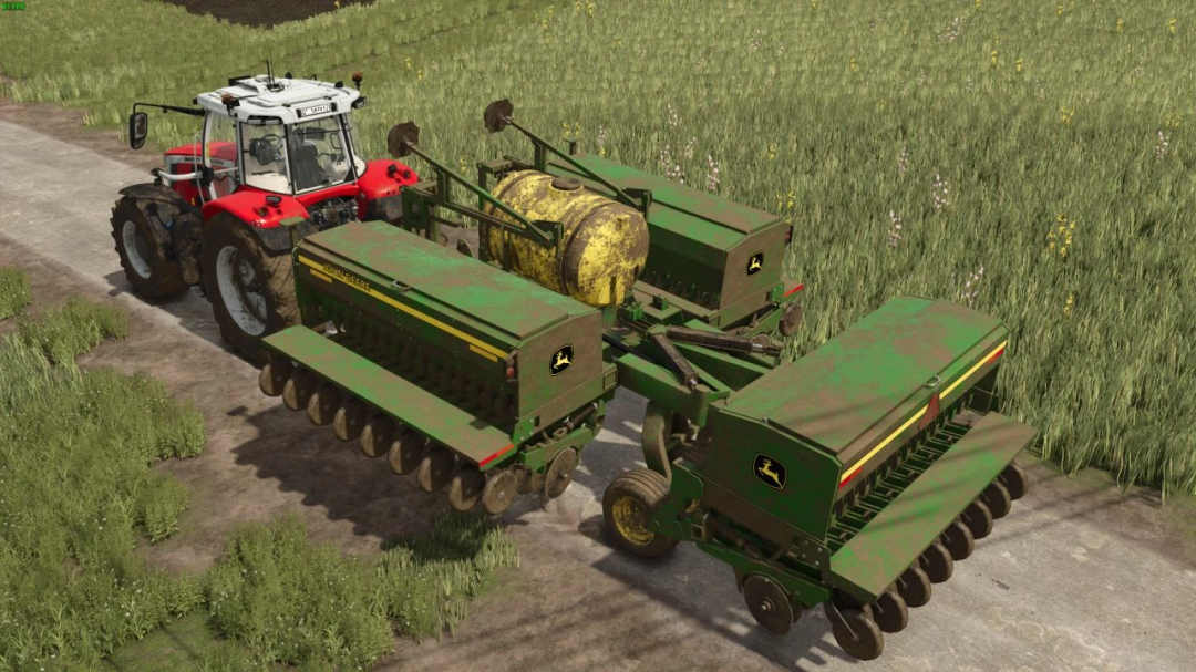 John Deere 455 Box Drill mod in FS25, attached to a red tractor on a dirt road with grass fields.