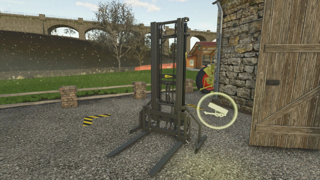 Pallet fork with tension belt mod in Farming Simulator 25, near a stone wall and grassy field.