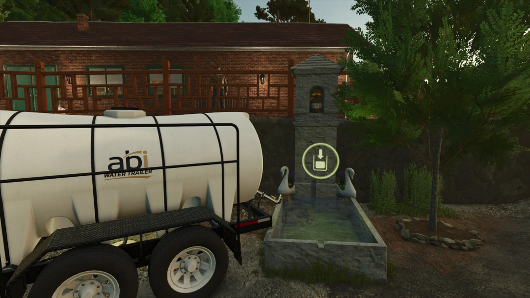 FS25 mod Farm Fountain v1.0.0.0 showing a water trailer beside a decorative stone fountain near a building and trees.