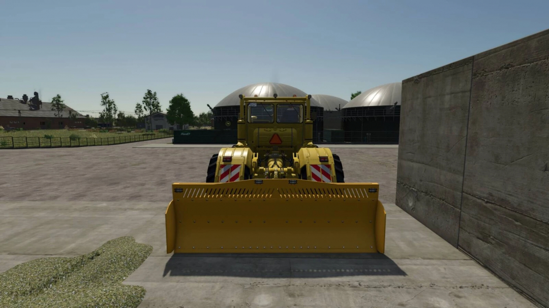 K700 tractor with sliding shield mod in FS25, positioned near silage bunker.