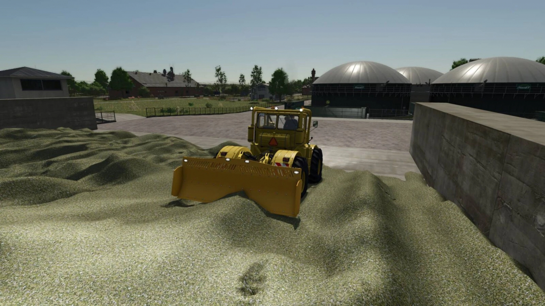 K700 tractor with sliding shield mod in FS25, pushing silage on a farm.