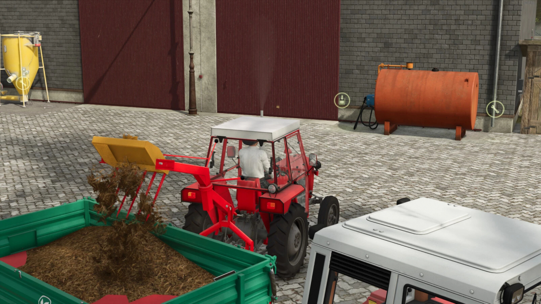 FS25 mod Lizard Panonija 525 v1.0.0.0: Red tractor loads manure into a green trailer on a cobblestone farmyard.