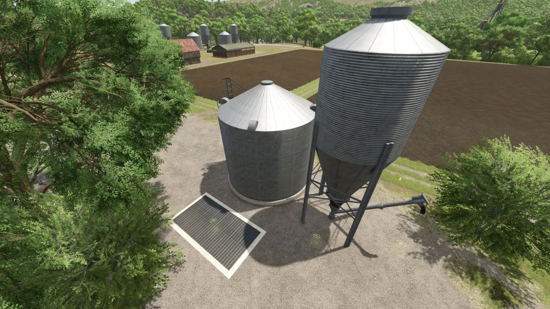 Aerial view of silo structures in FS25 Productions Pack mod, surrounded by trees and fields.