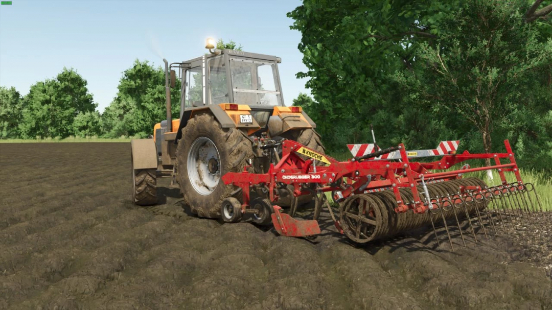 Renault TZ tractor mod in FS25 plowing a field with a red cultivator attachment, surrounded by trees.