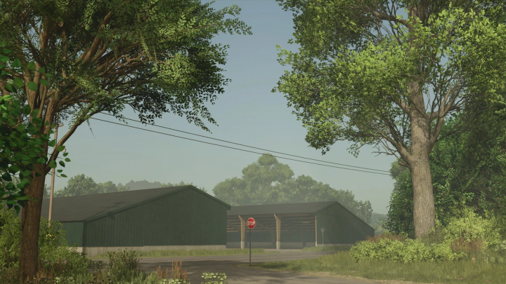 fs25-mods, Shed Pack mod in FS25 showing green sheds surrounded by trees and a stop sign on a sunny day.